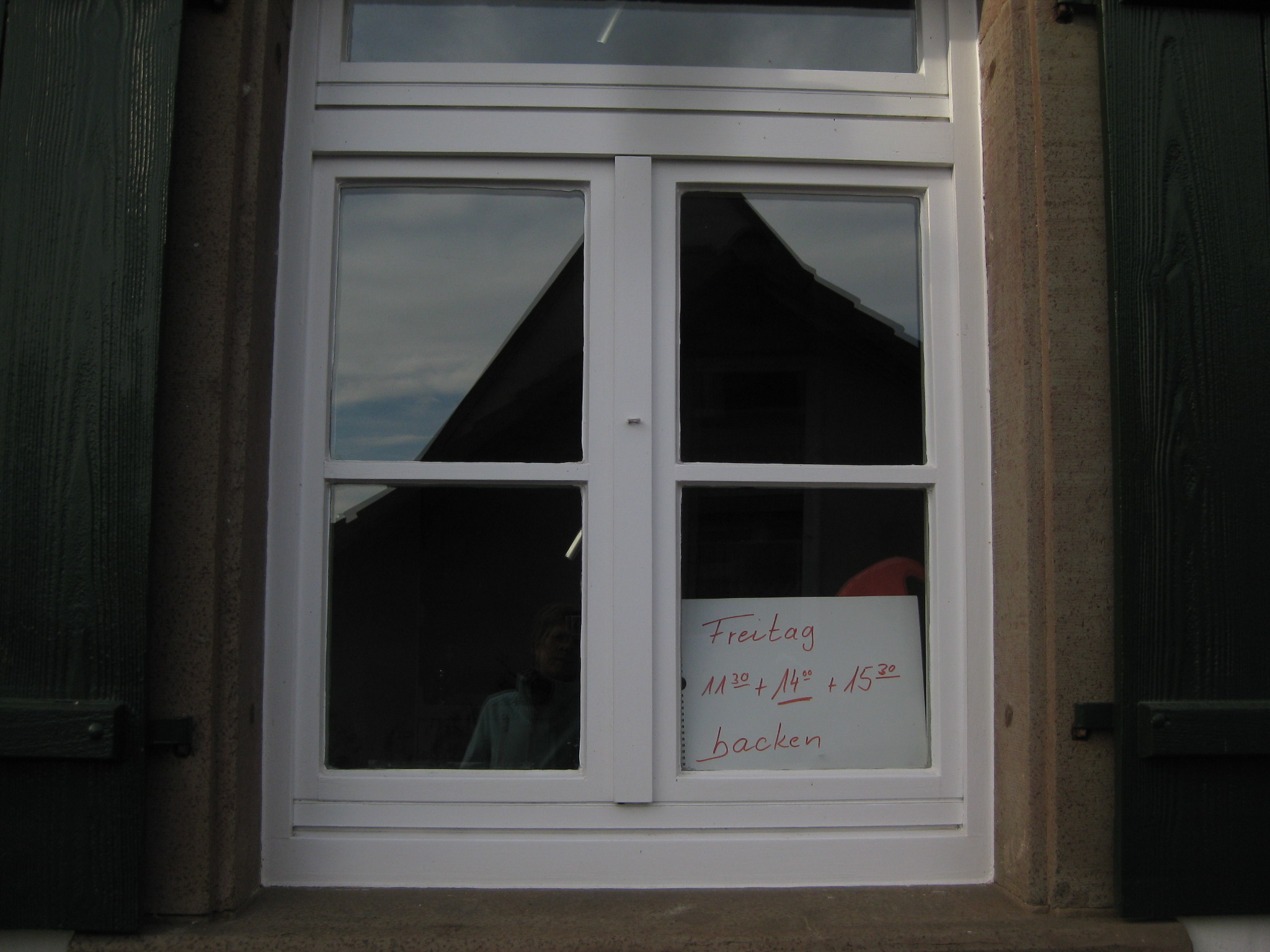  Nahaufnahme eines Fensters des Backhauses in Wiesenstetten mit den Öffnungszeiten. Freitag 11:30 Uhr, 14:00 Uhr und 15:30 Uhr - das Bild mit Klick vergrößern 