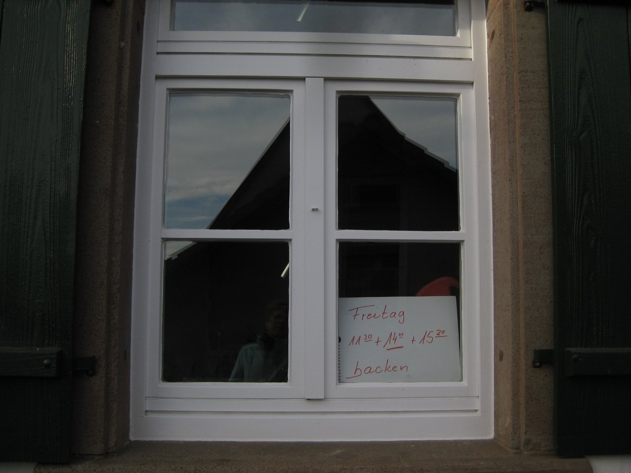 Nahaufnahme eines Fensters des Backhauses in Wiesenstetten mit den Öffnungszeiten. Freitag 11:30 Uhr, 14:00 Uhr und 15:30 Uhr - das Bild mit Klick vergrößern